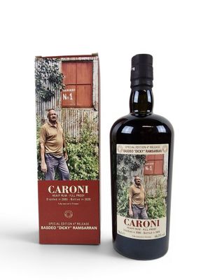 the bottle of caroni is next to a box of wine
