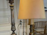 two lamps that are on a table with a chair in the background