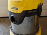 yellow and black vacuum cleaner sitting on the floor in front of a garage door