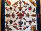 un gros plan d'un foulard carré posé sur une surface en bois