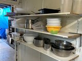 many pots and pans on the shelves in the kitchen