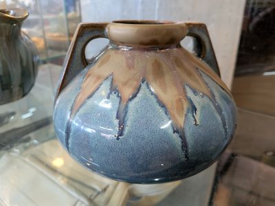 un vase bleu et marron exposé dans une vitrine