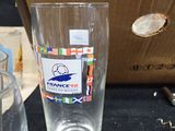 a glass of water sitting next to a box of wine glasses