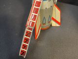a close up of a toy rocket with a ladder on it