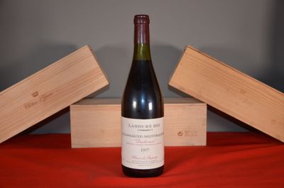 a bottle of wine sitting on a table next to two wooden boxes