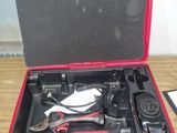 une mallette rouge contenant des outils, posée sur une table en bois