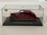 a red model car in a clear case on a table