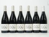 six bouteilles de vin sont alignées sur une table