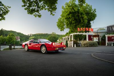 une voiture de sport rouge garée devant un immeuble