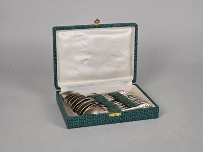 an image of a set of four silver and green spoons