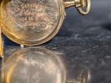 a close up of a person holding a gold pocket watch