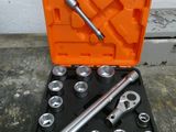 un ensemble d'outils rangés dans une boîte à outils posée par terre