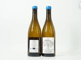 deux bouteilles de vin posées l'une à côté de l'autre sur une surface blanche