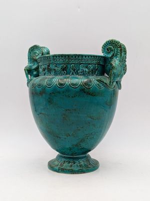 un grand vase vert orné de deux lions