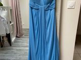 a blue dress hanging on a hanger in a room