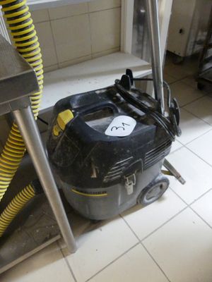 un aspirateur noir et jaune posé par terre dans une cuisine