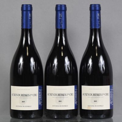 trois bouteilles de vin sont alignées sur une table