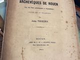 un vieux livre posé sur une table à côté d'une pile de livres