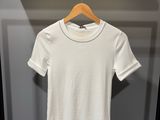 un t-shirt blanc suspendu à un cintre dans une armoire