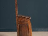 an old wooden chair sitting on top of a floor next to a blue wall