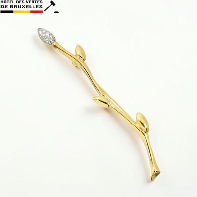 La broche en forme de fleur, en or et diamants, est représentée sur un fond blanc