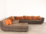 an image of a large sectional couch with orange pillows