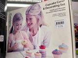 a box of cupcakes on a table with a woman and a child
