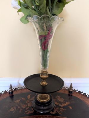 un vase en verre avec des fleurs posé sur une table dans une pièce