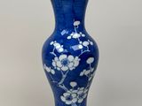 un vase bleu orné de fleurs blanches, posé sur une table