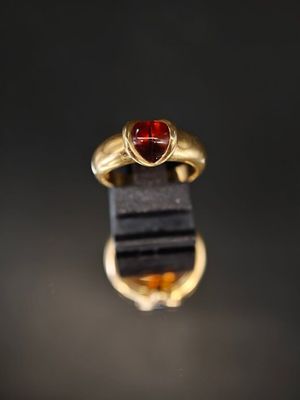 une bague en or avec une pierre rouge au centre