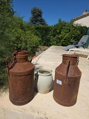 deux vieux bidons de lait posés l'un à côté de l'autre par terre