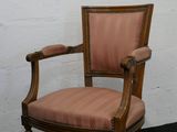 une chaise en bois avec une assise rembourrée rose