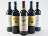 four bottles of wine are lined up on a white surface