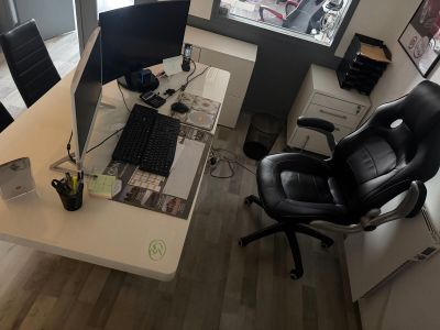 an overhead view of a desk with a computer and a chair