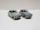 two toy cars sitting side by side on a white surface