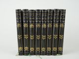 un lot de six livres noirs ornés de motifs dorés
