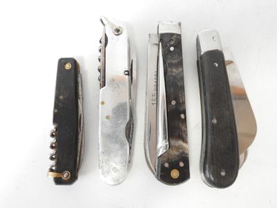 four different types of knives are lined up on a white surface