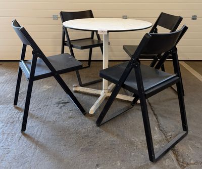 a white table with four black chairs around it