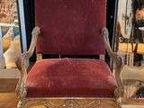 red velvet upholstered chair in front of a store window
