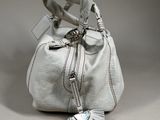 a white purse with a tassel hanging from it ' s handle