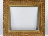 un vieux cadre photo peint en doré sur un mur blanc