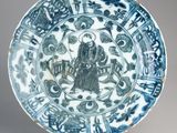 blue and white plate with a design of a man on a horse and a man on a horse