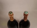two bottles of wine sitting next to each other on a table