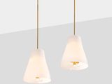 a pair of white and gold pendant lights hanging from a ceiling