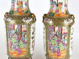 une paire de vases chinois anciens posés sur des socles, sur un fond blanc