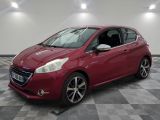 une voiture rouge est garée dans une pièce au sol en damier