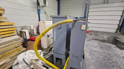 a picture of a machine in a warehouse with lots of wood