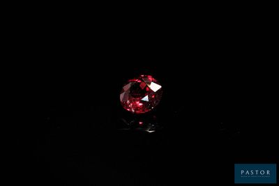 gros plan d'un diamant rouge sur une surface noire