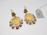 gros plan d'une paire de boucles d'oreilles sur une surface blanche
