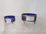 pair of silver and blue glass dishes on display in a glass case